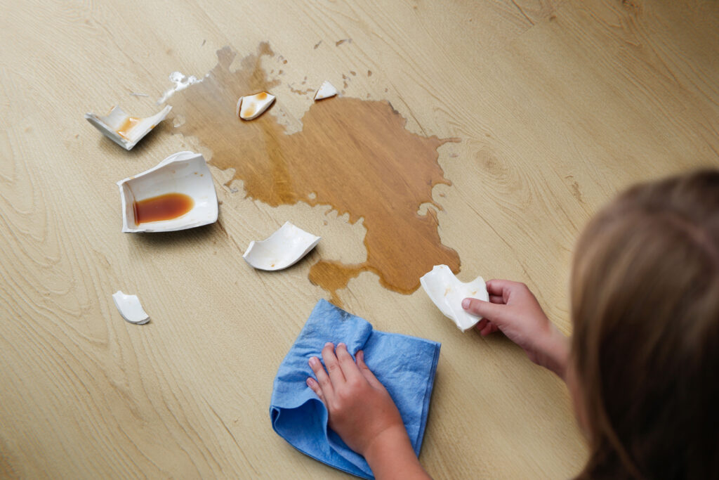 Rozlana kawa na panelach podłogowych w kuchni.